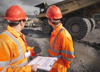Workers Inspecting Trucks In Coal Mine