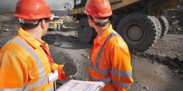 Workers Inspecting Trucks In Coal Mine
